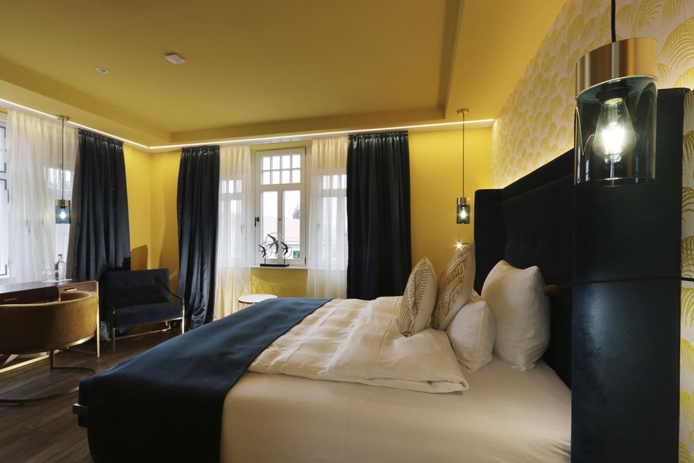 Mit gemütlichen Farben lädt das Zimmer und das große Doppelbett zum Entspannen ein.