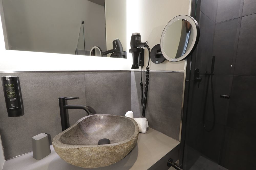 Das stilvoll eingerichtete Badezimmer glänzt mit Designelementen wie dem Waschbecken aus Stein.