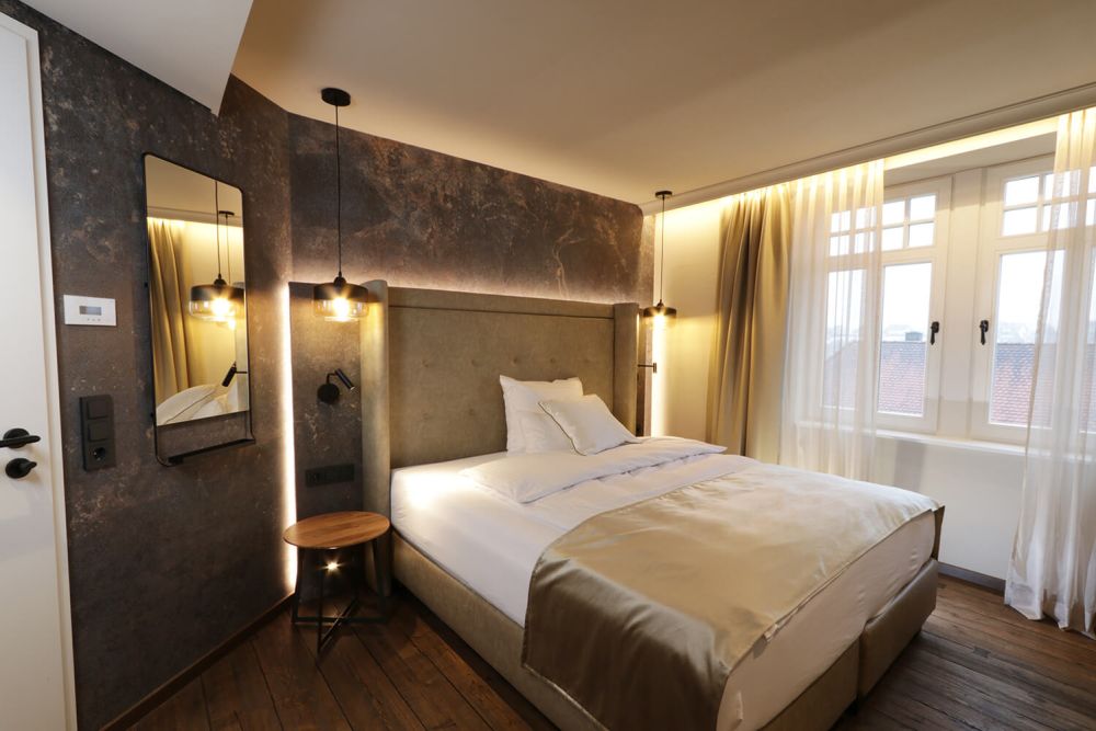 Die farblichen Akzente des stilvoll gestalteten Hotelzimmers werden durch die indirekte Beleuchtung untermalt.