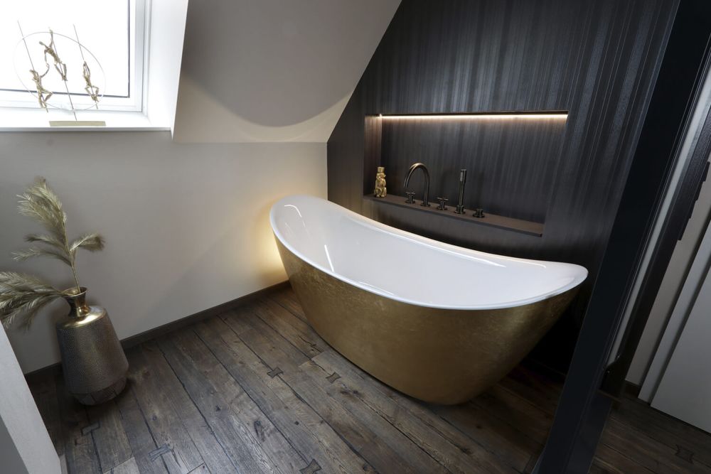 Die freistehende goldene Badewanne der Mansard Suite.