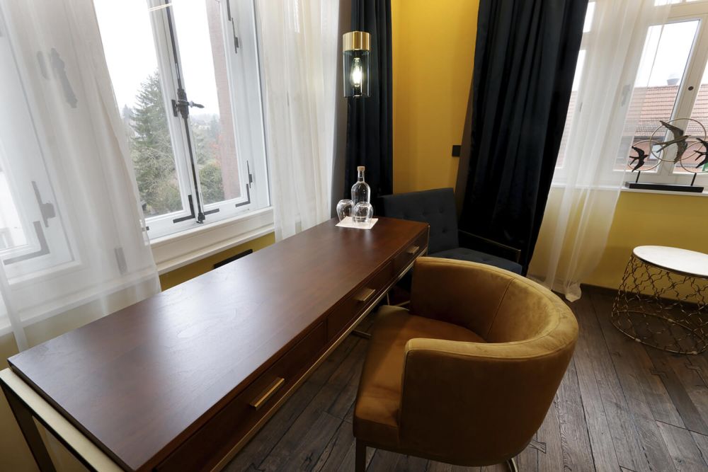Das Fenster direkt am stilvollem Tisch spendet Tageslicht beim Lesen und Arbeiten.