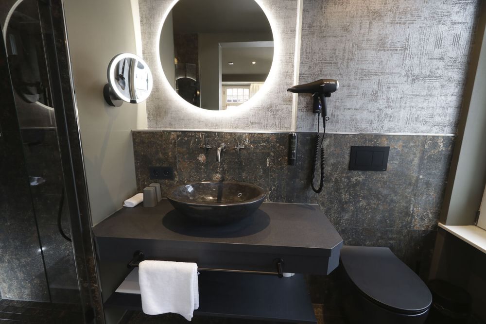 Das elegant gestaltete Badezimmer mit ebenerdiger Dusche.