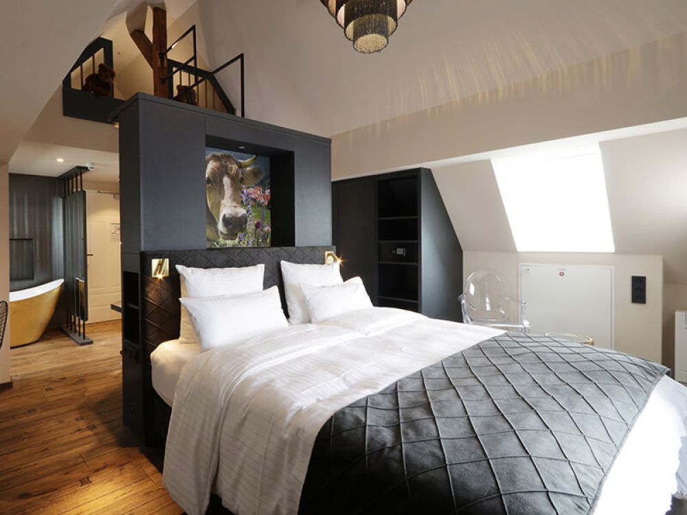 Ein Blick auf das elegante Doppelbett in der Mansarde Suite des Reinhardts Hotel