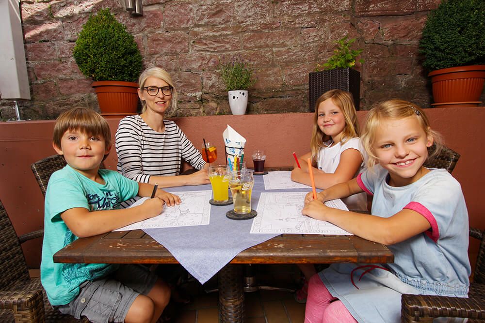 Familie mit Kindern sitzen am Tisch